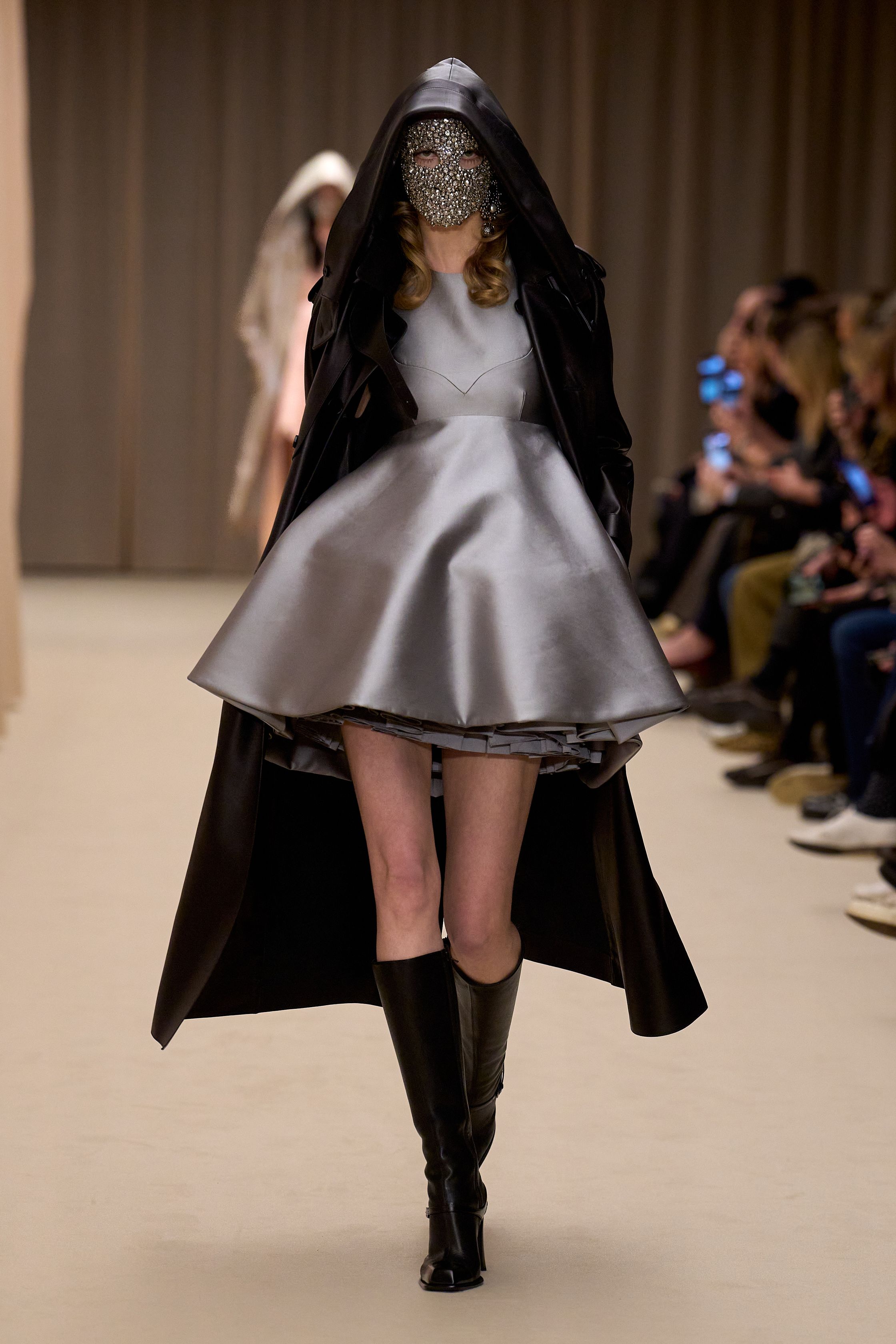 McQueen 本季延续品牌标志性的暗黑浪漫：收腰短裙套装、雕塑感肩线、精致刺绣礼服与戏剧化斗篷让整场秀充满哥特式戏剧张力。细腻蕾丝、金属光泽和建筑般轮廓塑造出强烈女性力量，同时保留麦昆一贯的浪漫与神秘-顽石频道趋势研究